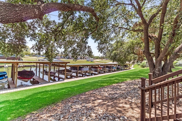 dock area featuring boat lift and a lawn