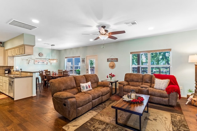 living area with dark wood finished floors, visible vents, and plenty of natural light