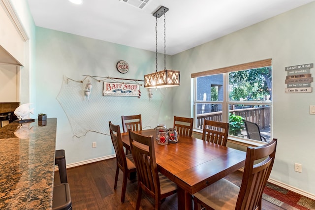 dining space featuring dark wood-style floors, visible vents, and baseboards