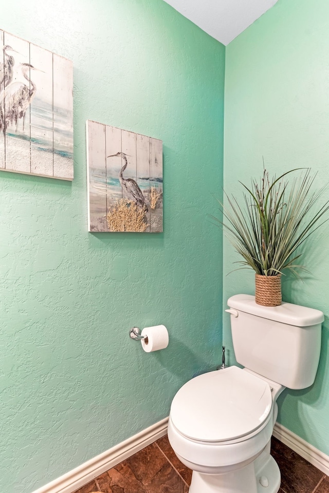 bathroom featuring baseboards and toilet