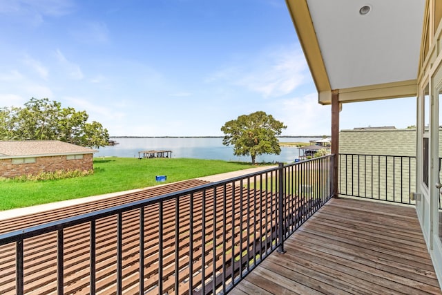 wooden deck featuring a lawn and a water view