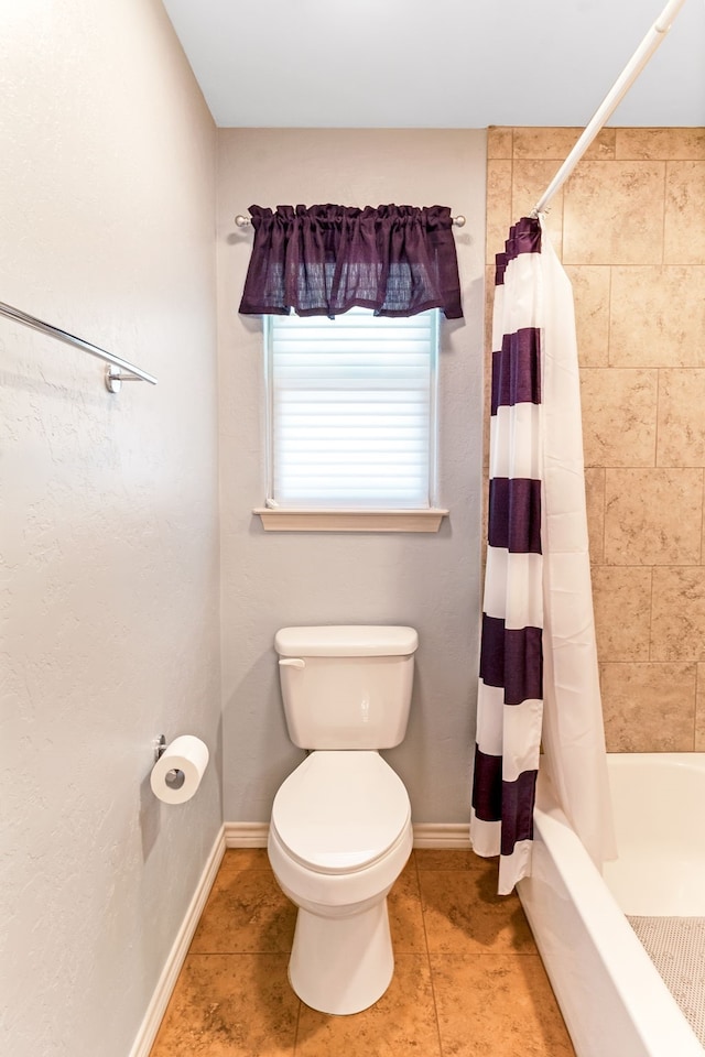 full bathroom with shower / bath combo, tile patterned flooring, toilet, and baseboards