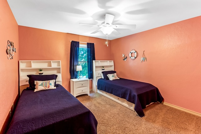 carpeted bedroom featuring baseboards and a ceiling fan