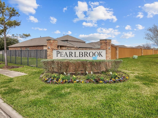 community sign featuring fence and a lawn