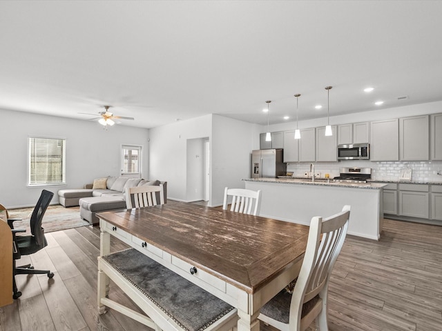 dining space featuring light wood finished floors, a ceiling fan, and recessed lighting