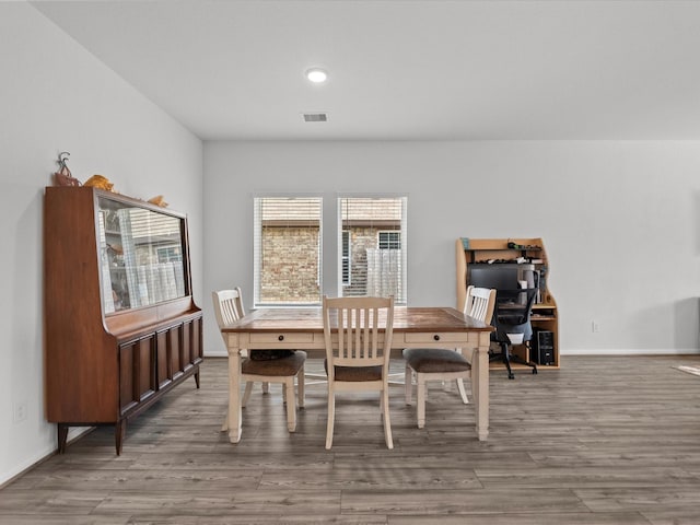 dining area featuring visible vents, baseboards, and wood finished floors