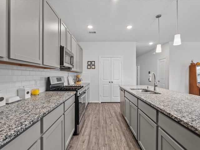 kitchen featuring a sink, visible vents, appliances with stainless steel finishes, gray cabinets, and tasteful backsplash