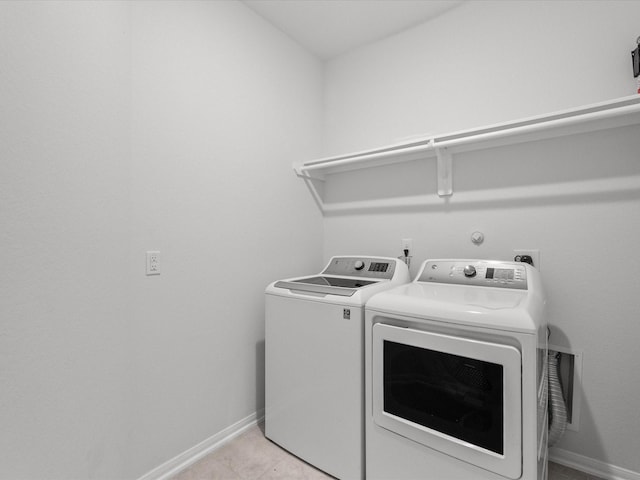 laundry room with laundry area, independent washer and dryer, baseboards, and light tile patterned floors