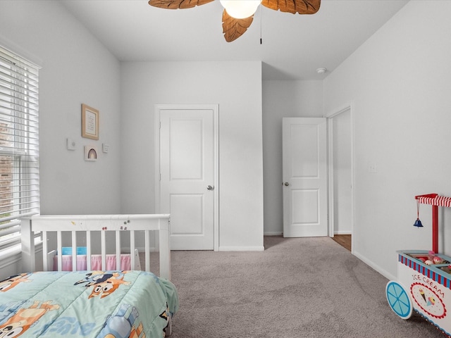 carpeted bedroom with ceiling fan and baseboards