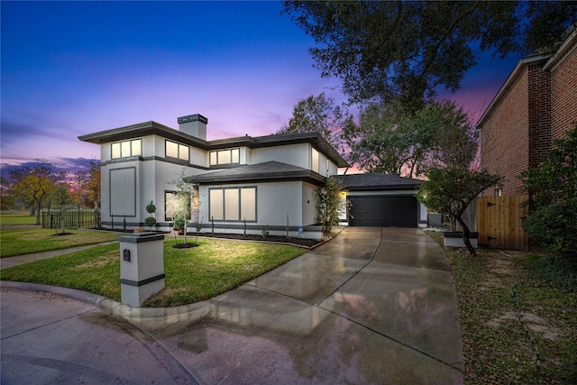 view of front of property featuring a garage, fence, concrete driveway, stucco siding, and a front yard