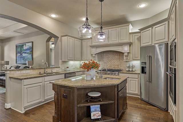 kitchen with a sink, stainless steel appliances, arched walkways, and open shelves