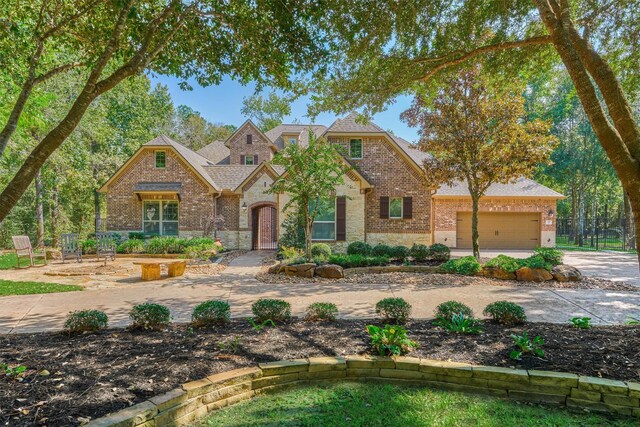 view of front of house featuring concrete driveway, stone siding, an attached garage, fence, and brick siding