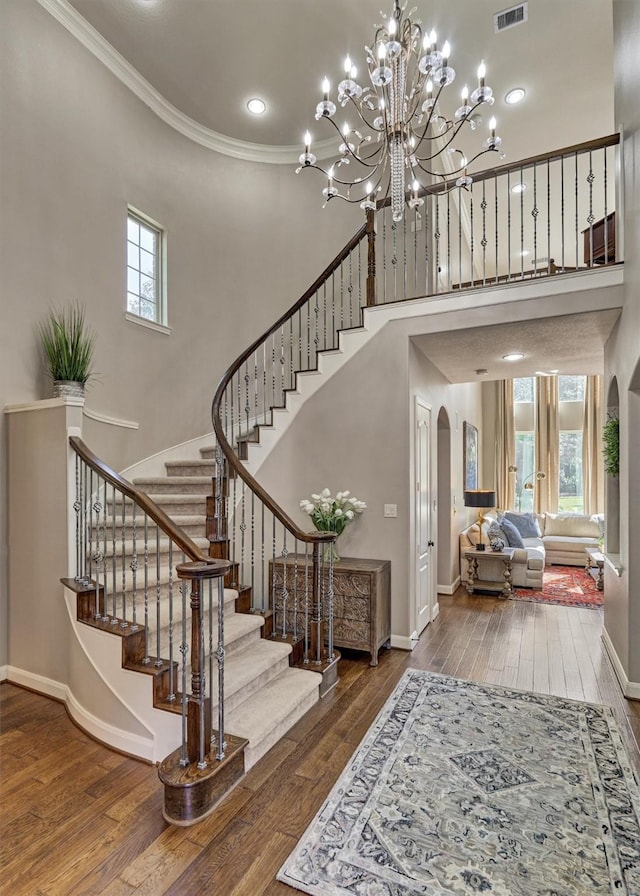 entrance foyer with arched walkways, hardwood / wood-style flooring, and a healthy amount of sunlight