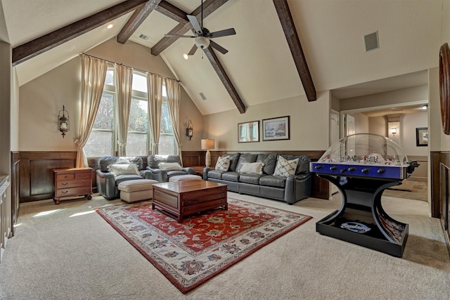 carpeted living room with visible vents, beamed ceiling, and wainscoting