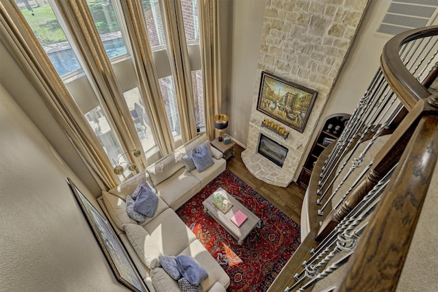 living room featuring stairs, a fireplace, and wood finished floors