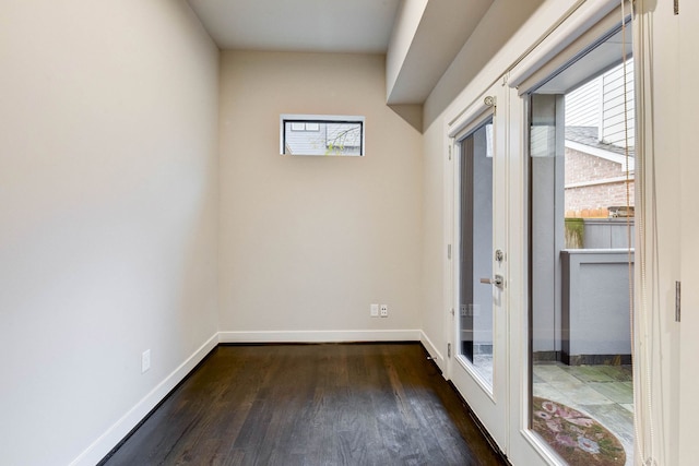 spare room featuring baseboards, dark wood finished floors, and french doors