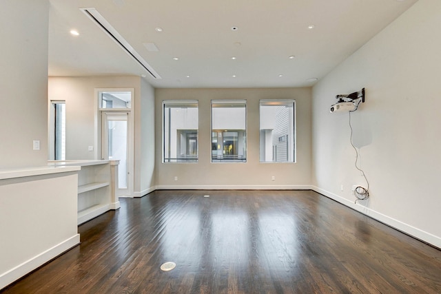 spare room with dark wood-type flooring, recessed lighting, and baseboards