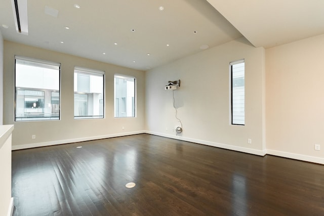 empty room featuring dark wood-style flooring and baseboards