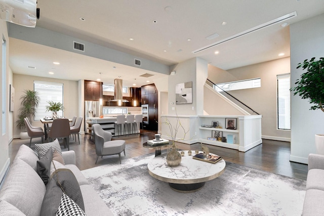 living room featuring recessed lighting, visible vents, baseboards, and wood finished floors