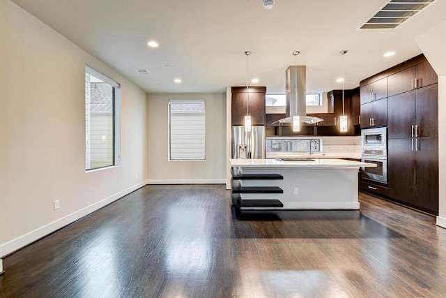 kitchen featuring light countertops, visible vents, appliances with stainless steel finishes, dark brown cabinetry, and island range hood