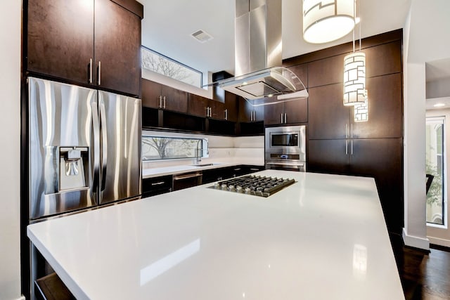 kitchen with dark brown cabinetry, stainless steel appliances, a sink, light countertops, and island exhaust hood