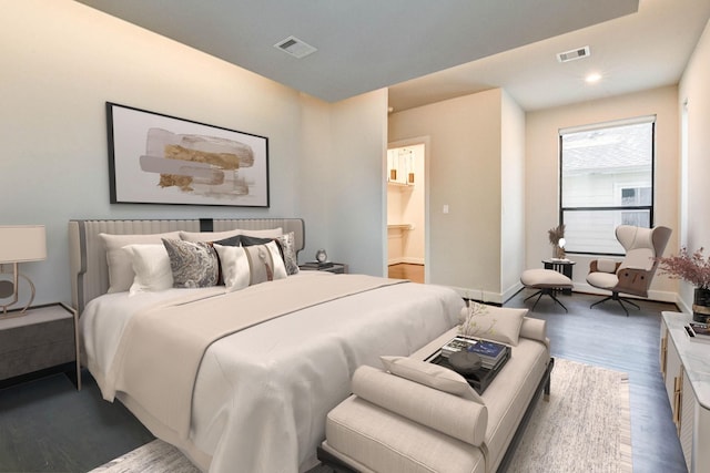 bedroom featuring baseboards, visible vents, and wood finished floors