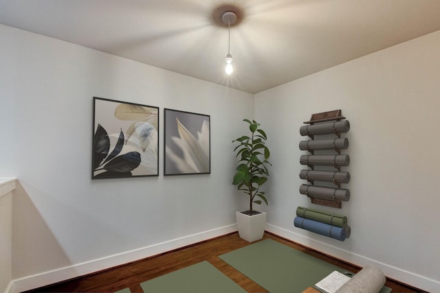 exercise room featuring wood finished floors and baseboards