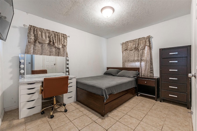 bedroom featuring a textured ceiling and light tile patterned flooring