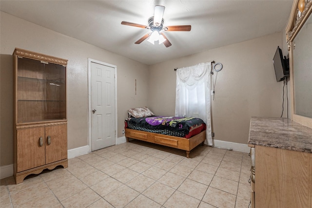 bedroom with light tile patterned flooring, ceiling fan, and baseboards