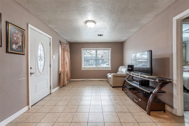 foyer entrance with visible vents, baseboards, and light tile patterned floors