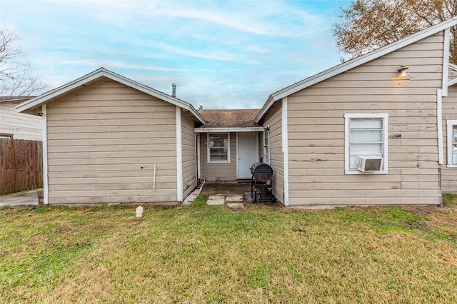 back of house with cooling unit, fence, and a lawn