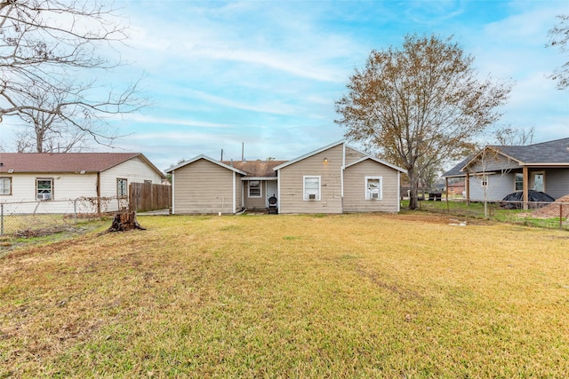 back of property featuring fence and a lawn