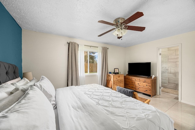 bedroom with ensuite bath, light tile patterned floors, ceiling fan, and a textured ceiling