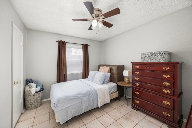 bedroom with light tile patterned floors, baseboards, a ceiling fan, and a textured ceiling