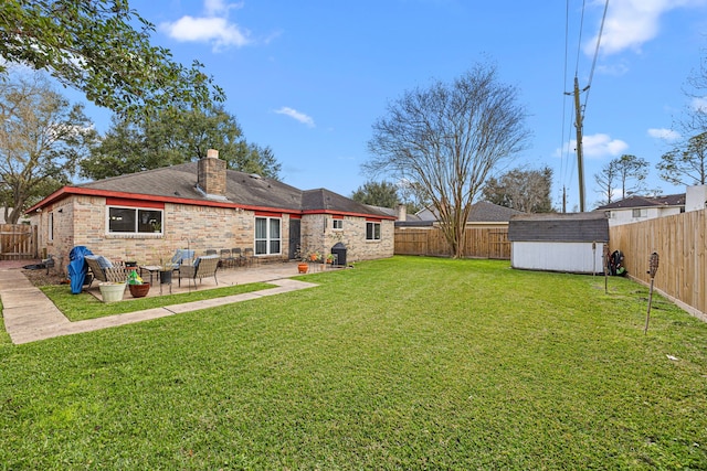 view of yard with a patio area, a fenced backyard, a shed, and an outdoor structure