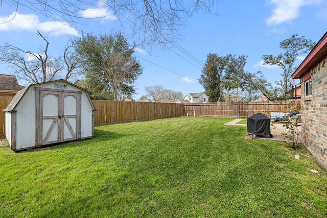 view of yard featuring a fenced backyard, a shed, a patio, and an outbuilding