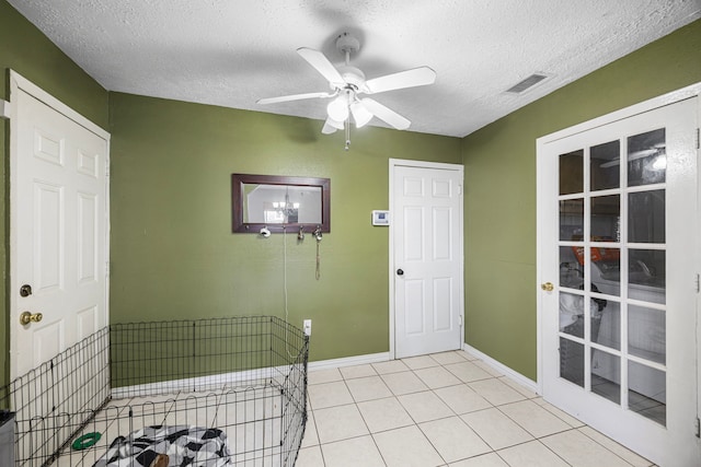 foyer with a ceiling fan, visible vents, a textured ceiling, and light tile patterned flooring