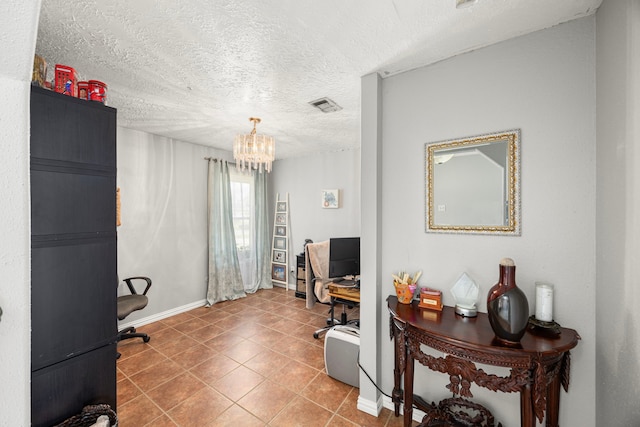 office space featuring visible vents, an inviting chandelier, a textured ceiling, tile patterned flooring, and baseboards