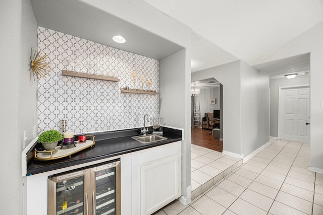 kitchen with beverage cooler, a sink, white cabinetry, open shelves, and dark countertops