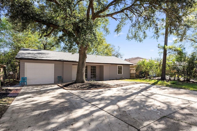 view of front of property with an attached garage, fence, and concrete driveway