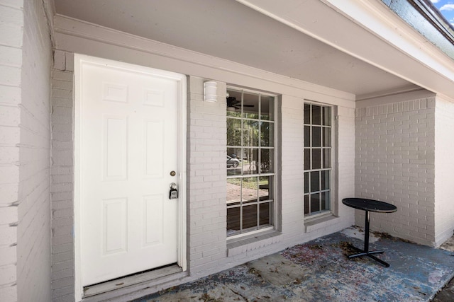 entrance to property featuring brick siding