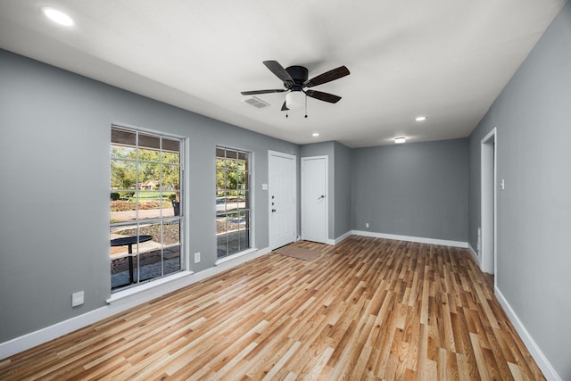 spare room featuring wood finished floors, a ceiling fan, and baseboards