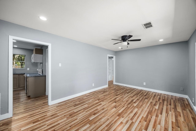 empty room with light wood finished floors, recessed lighting, visible vents, a ceiling fan, and baseboards