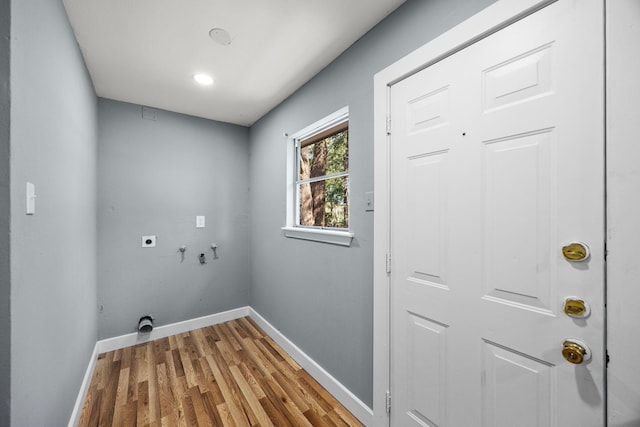 clothes washing area featuring laundry area, baseboards, light wood-style flooring, hookup for a washing machine, and electric dryer hookup