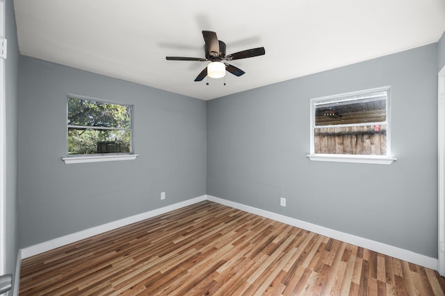 unfurnished room featuring ceiling fan, baseboards, and wood finished floors