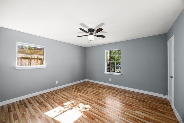 spare room with a ceiling fan, baseboards, and wood finished floors