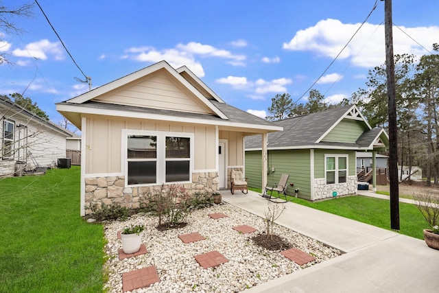 view of front facade featuring stone siding, a front lawn, and board and batten siding