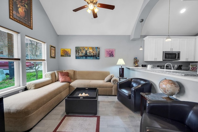 living room with a ceiling fan and high vaulted ceiling