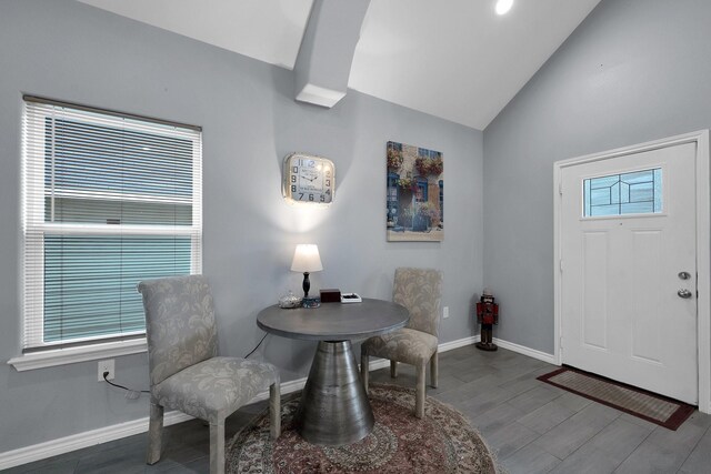 foyer with baseboards, vaulted ceiling, and wood finished floors