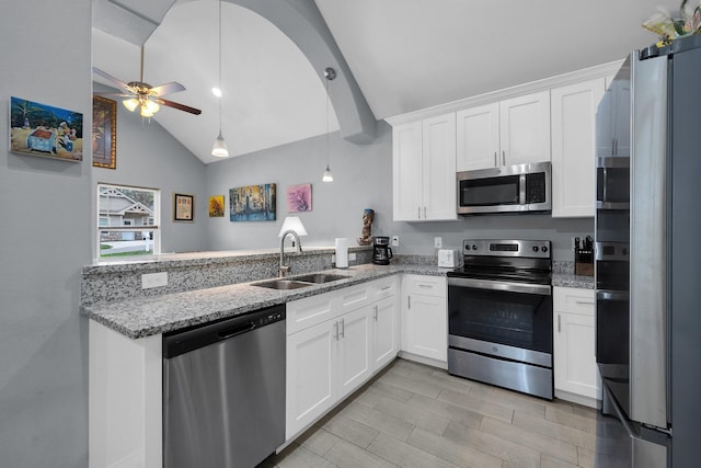 kitchen featuring stainless steel appliances, white cabinetry, a sink, ceiling fan, and a peninsula